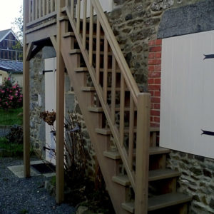 Escalier extérieur droit en bois IROKO spécial extérieur avec palier. Double crémaillère, sans contremarches, et rampe, teinte chêne moyen. Main courante standard avec gorges.