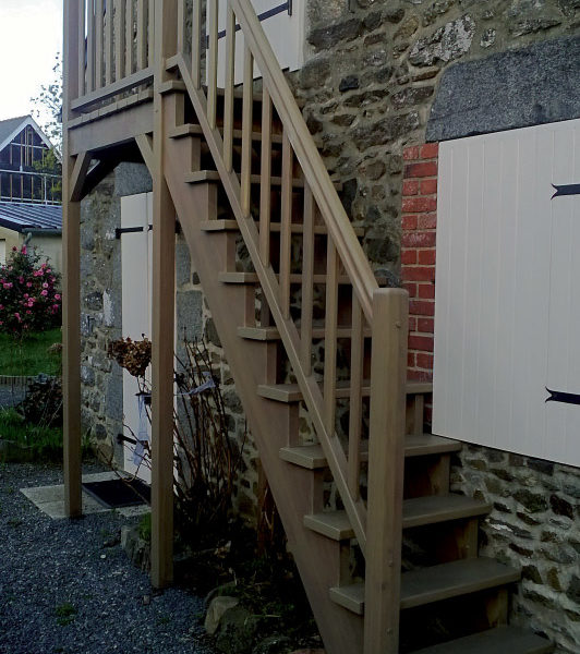 Escalier extérieur droit en bois IROKO spécial extérieur avec palier. Double crémaillère, sans contremarches, et rampe, teinte chêne moyen. Main courante standard avec gorges.