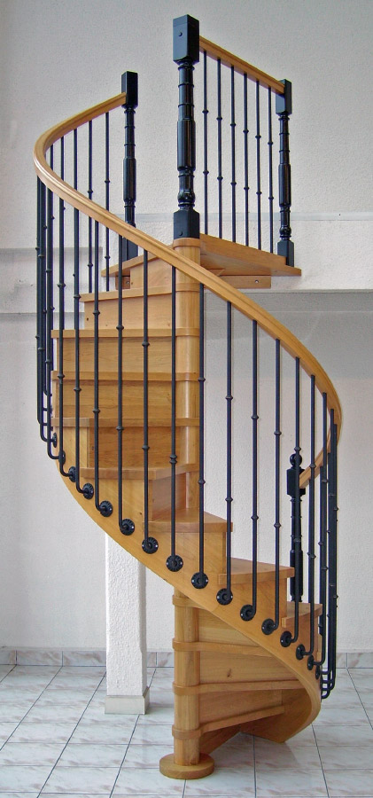 Escalier en bois hélicoïdal (colimaçon) teinte chêne clair avec contremarches. Rampe : main courante en bois teinte chêne clair avec gorges, balustres en fer forgé teinte noire avec débords, poteaux bois et métal noirs forgés.