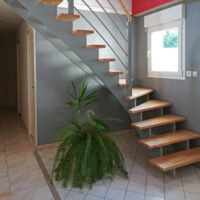 Escalier double crémaillères centrales en bois avec crémaillères teintées gris et marches vernis mat