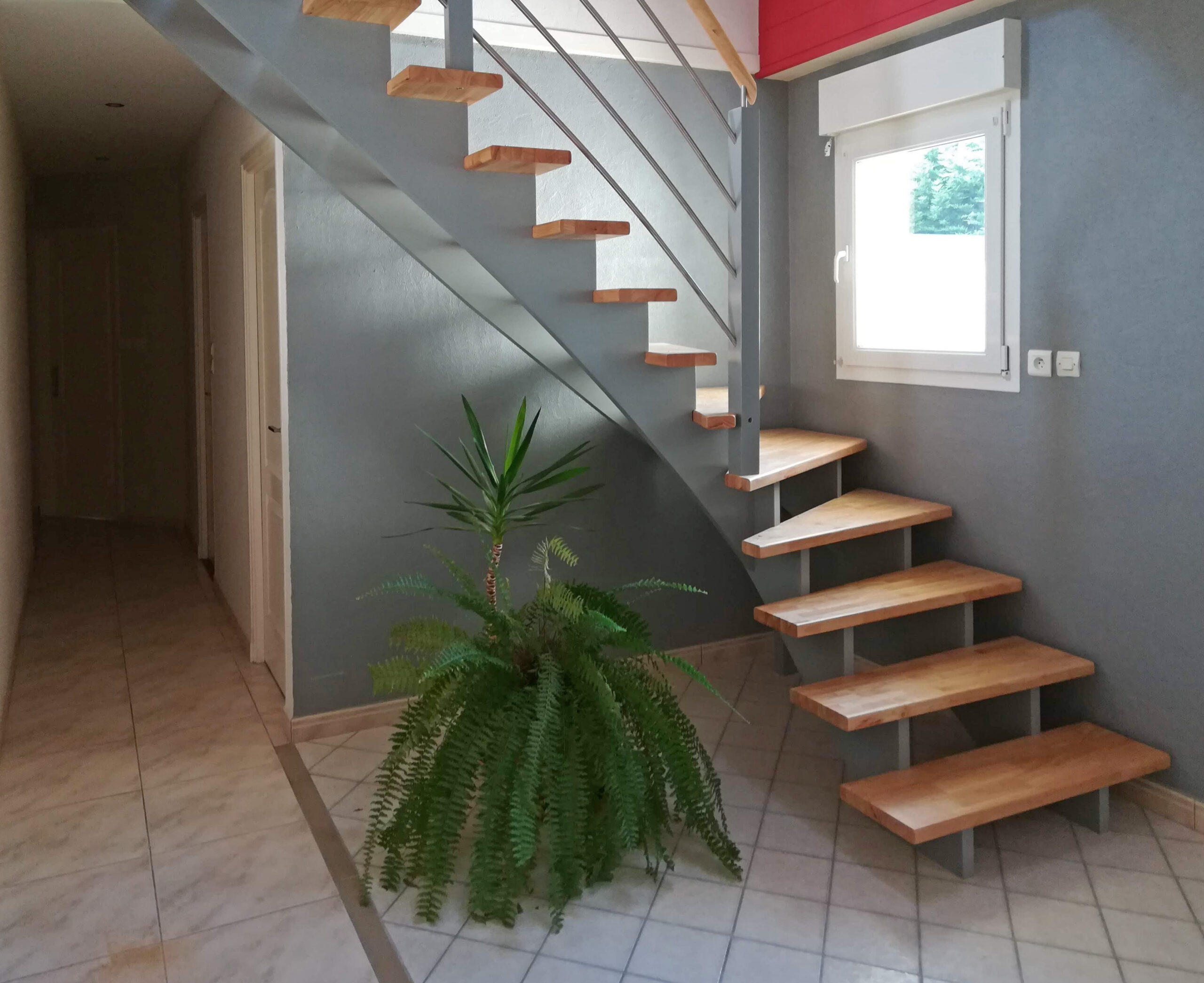 Escalier double crémaillères centrales en bois avec crémaillères teintées gris et marches vernis mat