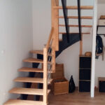 Escalier double crémaillères centrales en bois avec crémaillères teintées noires et marches vernis mat
