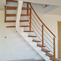 Escalier limon central bois teinté blanc et marches vernis naturel avec rampe bois et tubes inox