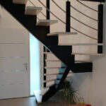 Escalier limon central bois teinté noir et marches blanchies avec rampe bois