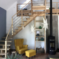 Escalier limon central bois vernis naturel avec rampe et garde-corps bois sur palier