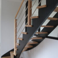 Escalier une crémaillère de jour en bois avec crémaillères teintées noir et marches vernis mat
